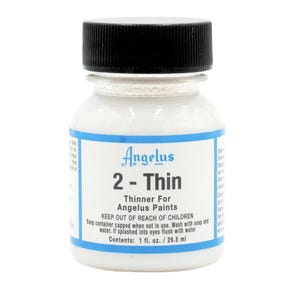 Può includere: Una bottiglia bianca di Angelus 2-Thin Thinner per vernici Angelus. La bottiglia è etichettata con il nome del prodotto, le istruzioni per l'uso e il contenuto: 1 fl. oz. / 29,5 ml.