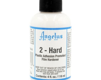 Puede incluir: Una botella blanca con una tapa negra etiquetada "Angelus 2 - Hard Plastic Adhesion Promoter/Film Hardener". La botella contiene 118 mililitros de líquido.