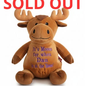 May include: A brown plush moose toy with antlers, dark brown hooves, and black eyes. The chest features purple embroidered text that reads: It's Moose for when Dan is at the House! The top of the image displays the red text: SOLD OUT.