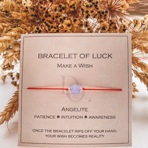 Puede incluir: Pulsera de cuerda roja con una cuenta de angelita azul claro. La tarjeta dice "Pulsera de la suerte, Pide un deseo, Angelita, Paciencia * Intuición * Conciencia, Una vez que la pulsera se rompa, tu deseo se hará realidad."