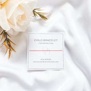 Peut inclure: Bracelet en cordon rouge sur une carte blanche avec le texte "Bracelet enfant pour la protection" et "Cordon de soie Protection Foi Bonne chance".