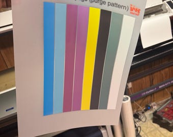 May include: A white sheet of paper with 8 colour test strips. The strips are blue, light blue, purple, yellow, black, grey, and white. The text "8 Colour test page (purge pattern)" is printed at the top of the page. The text "WKS Wrap" is printed in the top right corner of the page.