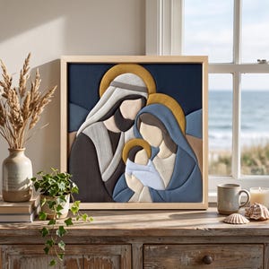 May include: A square wooden framed wall art piece featuring a stylized layered depiction of a family with a baby. The figures are rendered in shades of navy blue, light blue, cream, and gold, set against a dark blue background.