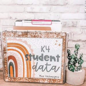 May include: A clear plastic file box with a colorful rainbow design and the text "K4 student data Mrs. Wehmeyer".