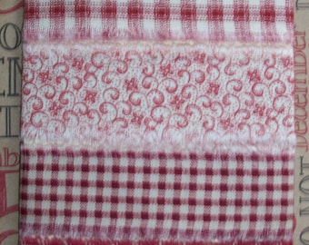May include: Four different red and white plaid ribbon trims with frayed edges. The ribbons are arranged vertically on a white card with a green bow and a red and green Christmas tree charm at the top.