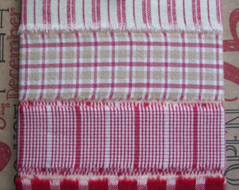 May include: Four different red and white plaid fabric samples with a frayed edge. The fabric samples are attached to a white card with a red ribbon and a green and white beaded charm.