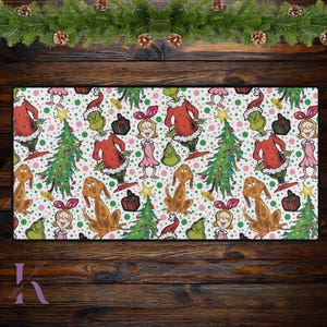 Puede incluir: Un fondo blanco con un patrón repetido de árboles verdes, personajes Grinch rojos y verdes, perros marrones y niñas rosas y blancas. El patrón está sobre un fondo blanco con lunares rosas.