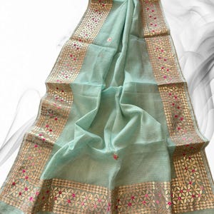 May include: A light blue sheer scarf with gold and pink embroidery. The embroidery features a floral pattern with small, round sequins.