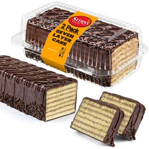 May include: A two-pack of seven-layer cake in a clear plastic container, with a rectangular cake and two slices visible. The cake has a chocolate glaze and chocolate sprinkles. The packaging has a yellow label with the text "Stern's Bakery".