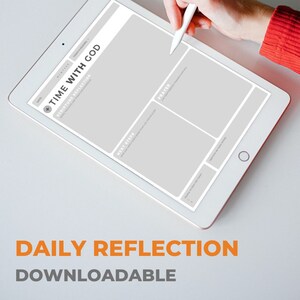 May include: A white tablet with a gray background and a white stylus. The tablet has a section labeled "Time with God" with subheadings "Scripture Reflection", "Next Steps", and "Prayer". The text "Daily Reflection Downloadable" is at the bottom of the image.
