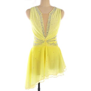 May include: A yellow sleeveless figure skating dress with a V-neckline and a rhinestone design. The dress has a layered skirt with a scalloped hem.