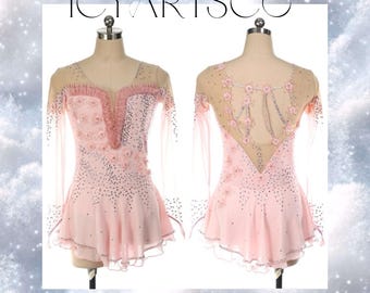 May include: A pink figure skating dress with long sleeves and a sheer bodice. The dress is decorated with pink flowers and rhinestones. The back of the dress has a sheer panel with a floral design.