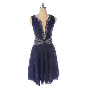 May include: A navy blue sleeveless dress with a V-neckline and a beaded design around the waist. The dress has a flowing skirt and is adorned with rhinestones.
