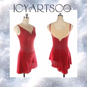 Puede incluir: Vestido de patinaje artístico rojo con escote y espalda transparentes, adornado con brillantes lentejuelas. El vestido tiene una falda fluida y se exhibe en un maniquí. El texto "ICYARTSCO" está en la parte superior.