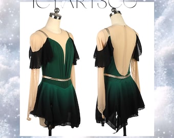 Puede incluir: Vestido de patinaje artístico con falda verde y negra, mangas transparentes y cinturón dorado. El vestido tiene un escote pronunciado y el texto "ICYARTSCO" en la parte superior.