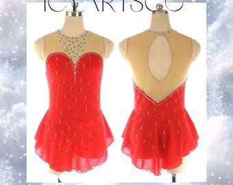 Op de afbeelding: Rode kunstschaatsjurk met een hartvormige halslijn en een transparant achterpaneel. De jurk is versierd met strass en heeft een gelaagde rok.