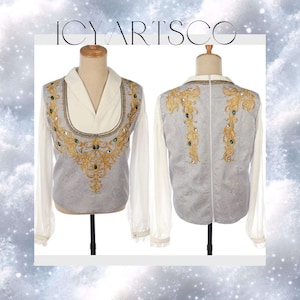 May include: A light grey and white shirt with gold embroidery and jewel accents. The shirt has long sleeves and a decorative front and back design. The text "ICYARTSCO" is at the top of the image.