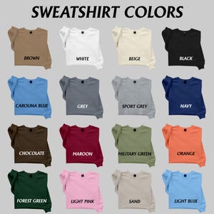 May include: A color chart titled SWEATSHIRT COLORS displaying sixteen crewneck sweatshirts in various shades including brown, white, beige, black, carolina blue, grey, sport grey, navy, chocolate, maroon, military green, orange, forest green, light pink, sand, and light blue.