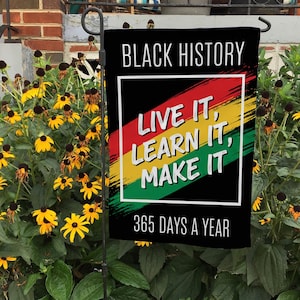 May include: Black History garden flag with the text "BLACK HISTORY" at the top. Below, the flag features the text "LIVE IT, LEARN IT, MAKE IT" in white, over a red, yellow, and green stripe design. The bottom reads "365 DAYS A YEAR".