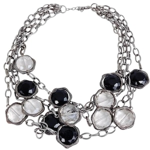 May include: A silver chain necklace with black and clear faceted beads. The necklace is layered and has a delicate chain.