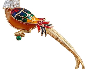 May include: A gold-tone brooch featuring a detailed enamel bird with a long tail. The bird is decorated with red, yellow, green, and blue enamel. The bird's head is adorned with a clear rhinestone.