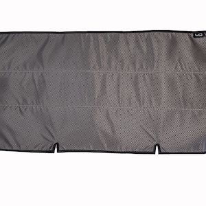 May include: A black mesh car window shade with a black border and a small black tag with the letters "LG" on it.