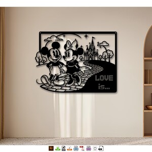 Pode incluir: Arte de parede em metal preto com Mickey e Minnie Mouse caminhando de mãos dadas em um caminho de tijolos em direção a um castelo. As palavras "LOVE is..." são exibidas no caminho. A obra de arte é colocada contra uma parede neutra.