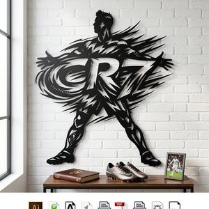 May include: A black metal wall art piece depicting a stylized soccer player in a dynamic pose with the text CR7 integrated into the design. The silhouette features sharp, angular lines and cutouts, showcasing a player with arms outstretched.
