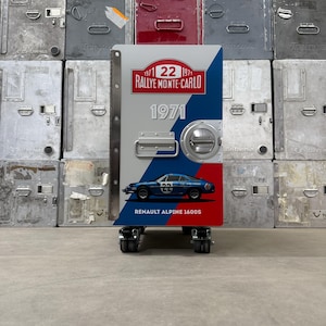 May include: A blue, white, and red metal cabinet with a vintage car design. The cabinet has a handle and a round door knob. The text on the cabinet reads "1971 22 1971 RALLYE MONTE-CARLO 1971 RENAULT ALPINE 1600S".