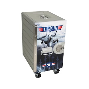 May include: A silver metal storage chest with the Top Gun logo and an image of a fighter jet. The chest has a handle on top, a latch, and is mounted on four wheels. The design includes a star and stripes emblem.