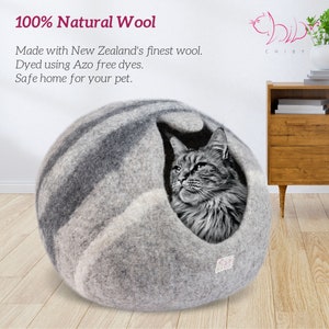 May include: A gray and white wool cat bed shaped like a sphere with a cat peeking out of the opening. The bed is made with 100% natural wool from New Zealand and is dyed with azo-free dyes. The text "100% Natural Wool" is at the top of the image. The text "Made with New Zealand's finest wool. Dyed using Azo free dyes. Safe home for your pet." is below the image of the cat bed.