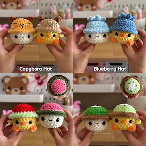 Pu&ograve; includere: Una collezione di quattro giocattoli a forma di pulcino all'uncinetto, ognuno con un cappello diverso: capibara, mirtillo, anguria e kiwi. I giocattoli sono gialli, bianchi e arancioni, con occhi neri. I cappelli sono marroni, blu, rossi, rosa e verdi. Il testo "thestitchstudioce" &egrave; visibile.