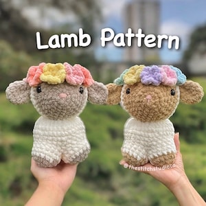 Könnte beinhalten: Zwei gehäkelte Lamm-Plüschtiere mit Blumenkränzen. Das Lamm links hat einen rosa, gelben und orangen Blumenkranz. Das Lamm rechts hat einen lila, blauen und grünen Blumenkranz. Beide Lämmer sind braun und weiß.