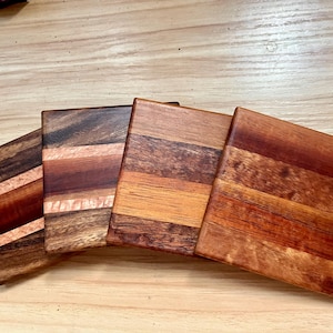 Puede incluir: Un juego de tres tazas de cerámica con un acabado mate moteado. Las tazas son de color crema, gris claro y gris oscuro. Cada taza tiene un diseño simple y minimalista.