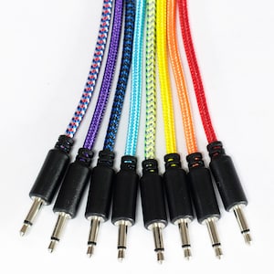 May include: Eight colourful braided cables with different coloured plugs. The cables are red, orange, yellow, green, blue, purple, and black.