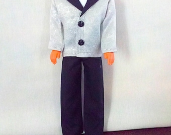 May include: A silver and black tuxedo with a bow tie. The jacket has a satin lapel and three black buttons. The pants are black.