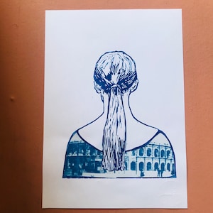 May include: A blue and white linocut print of a person with their back to the viewer. The person has their hair pulled back in a ponytail. The print is layered with an image of a building with arches.