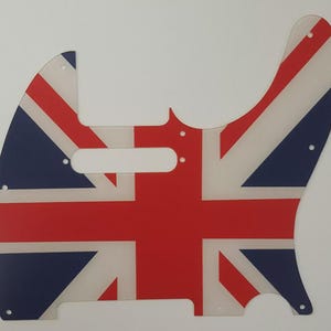 May include: A guitar pickguard displaying the Union Jack flag. The pickguard is transparent, with the red, white, and blue design of the UK flag. It has a distinctive shape, including screw holes and a pickup aperture.