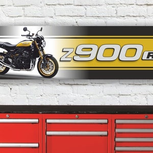 Op de afbeelding: Een zwart en geel motorbanner met een afbeelding van een Kawasaki Z900RS motorfiets en de tekst "Z900 RS".