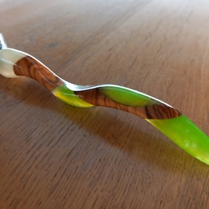 May include: A green and brown safety razor with a wooden handle. The handle is made of wood with a green resin inlay.