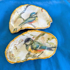 Puede incluir: Un juego de tres tazas de cerámica con un acabado moteado y mate. Cada taza presenta un color diferente: azul claro, crema y gris. Las tazas tienen un diseño simple y moderno y un asa cómoda.