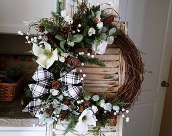 Magnolia and winter rose Winter wreath adorned with velvet berries, pine and pine cones , eucalyptus and lambs ear. Winter door decor .