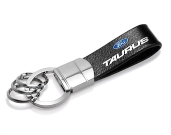 Imagen de iPick para Ford Taurus, correa de cuero auténtico negra, llavero de metal cromado con gancho redondo, licencia oficial.