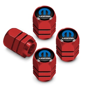 May include: A set of four red metal tire valve stem caps with a cylindrical shape and horizontal grooves. Each cap features a circular black top insert with a blue Mopar logo and the text MOPAR printed in white lettering on the face.