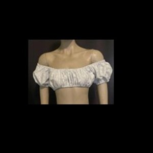 May include: A white off-the-shoulder crop top featuring short puff sleeves with elasticated cuffs and a gathered, ruched neckline. The garment is constructed from a lightweight fabric and sits above the waistline, exposing the midriff area.