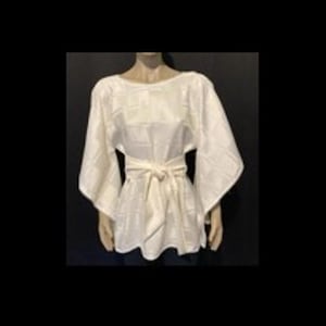 May include: A white blouse featuring a subtle tonal grid pattern, wide kimono-style sleeves, and a matching fabric tie belt at the waist. The garment has a round neckline and a loose, flowing silhouette that extends to the hip area.