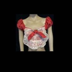May include: A cropped top featuring short puffed red sleeves and a white lace bodice. The garment includes a central red bow detail at the neckline, which is cut in a sweetheart style. The lace fabric has a floral pattern and scalloped edges.