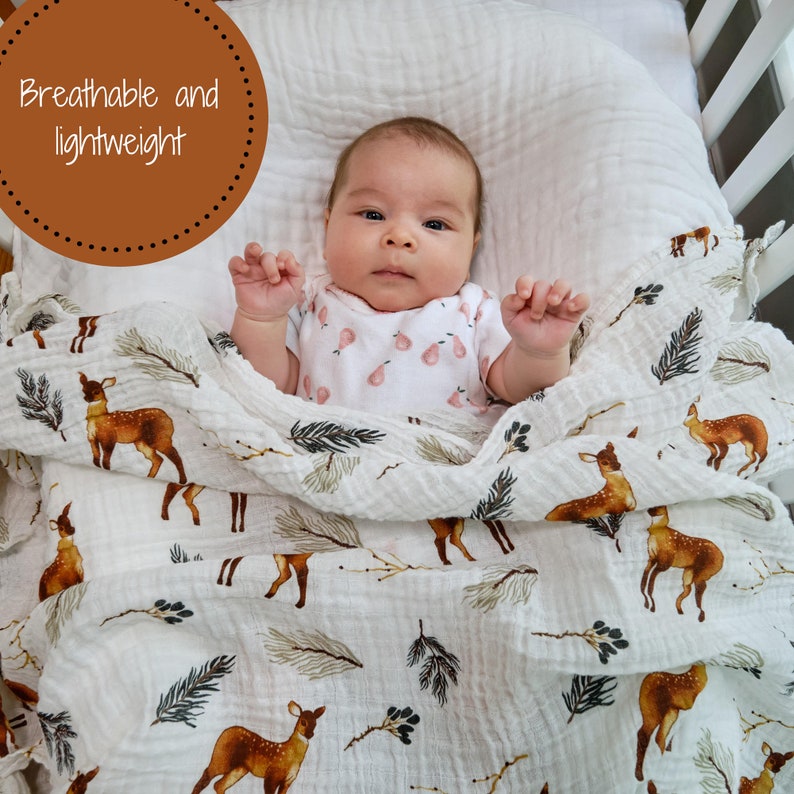 Multi-use deer print baby swaddle, doubling as a burp cloth and stroller cover, featuring a playful and enchanting forest design.