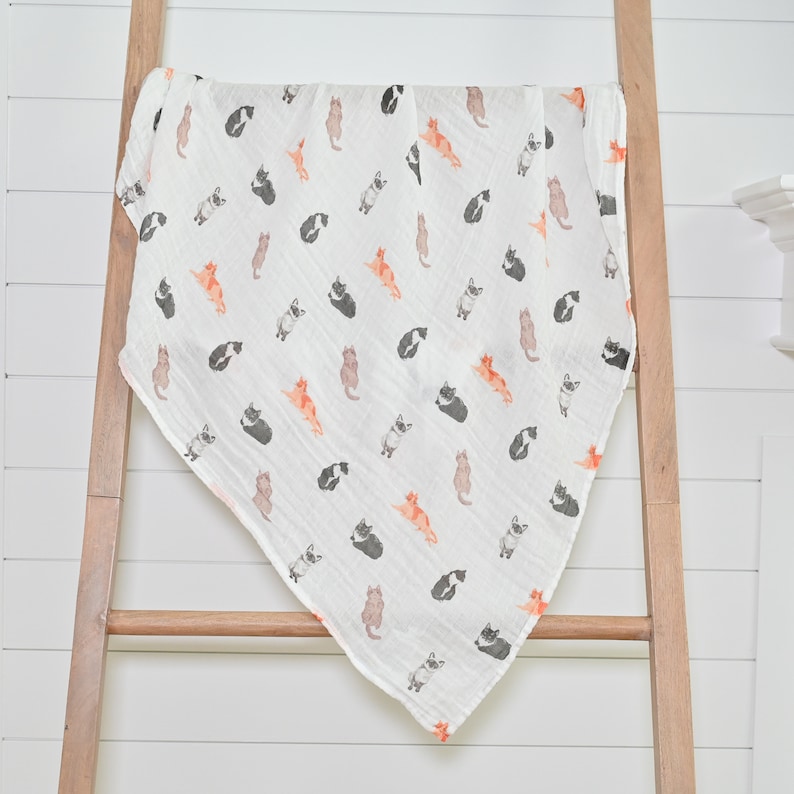 The swaddle's large 47"x47" size is perfect for wrapping or draping, featuring an adorable cat pattern.