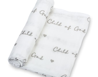 May include: White muslin swaddle blanket with the text "Child of God" repeated in a gray script font. The blanket is rolled up and features small gray hearts.